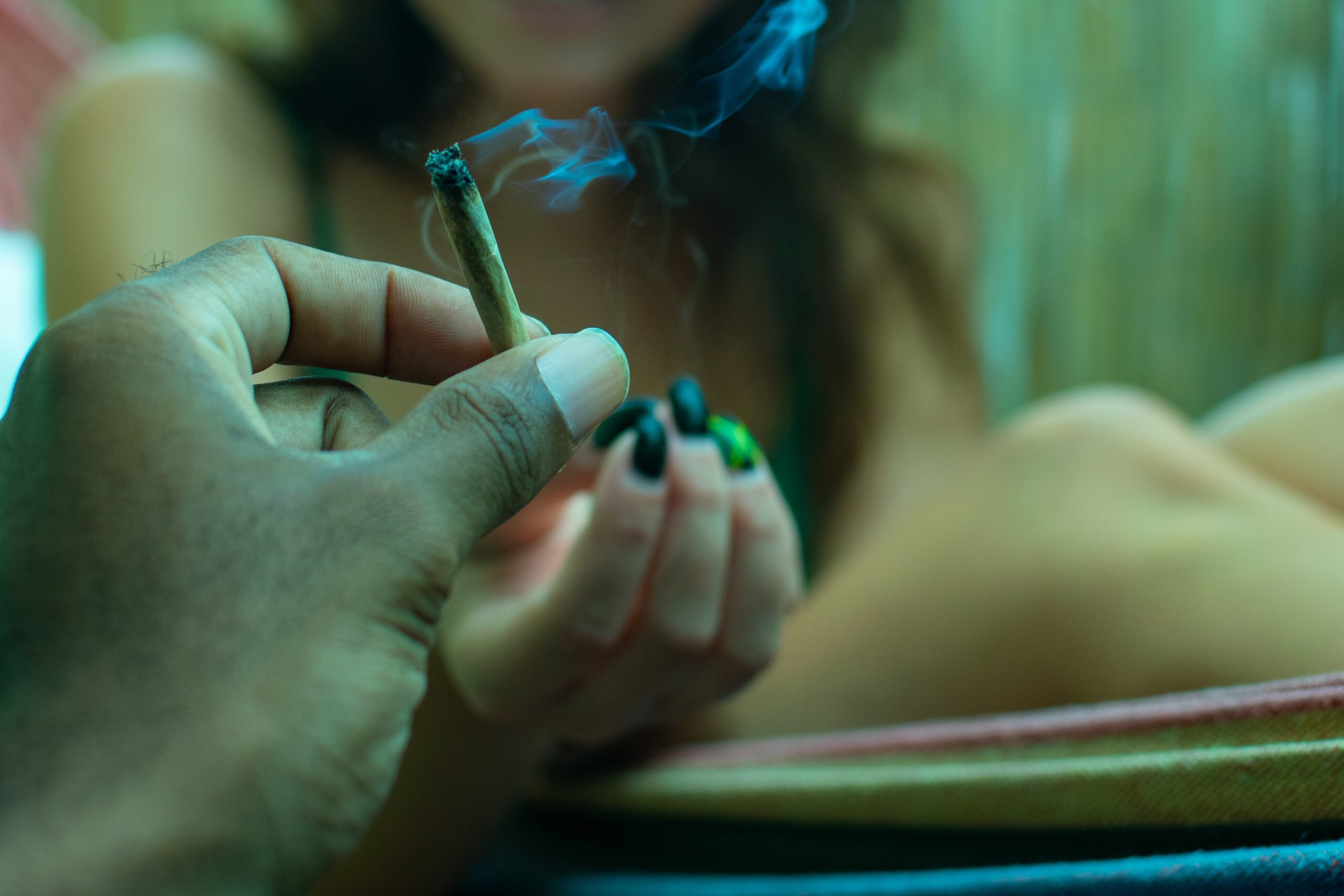 A person putting a lit up cigarette into the woman's hands